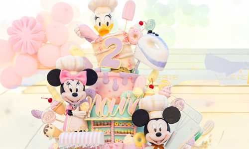 Pastel Disney-inspired birthday cake featuring Minnie and Mickey figurines
