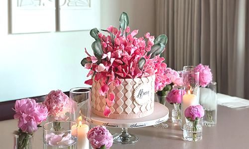 Elegant pink floral decorated cake centerpiece with sugar flowers and candles