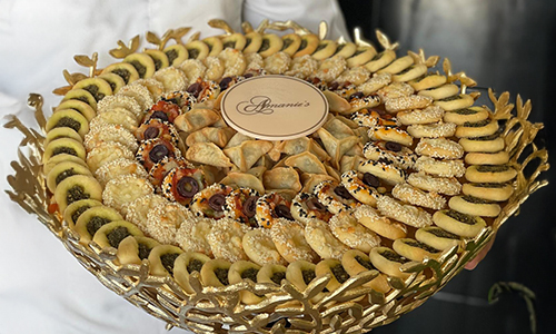 Mixed selection of filled pastries, manakeesh and baked appetizers on a gold tray
